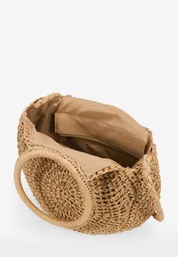 Bolso de paja trenzada con forma redonda, color beige y asas circulares. El interior cuenta con un forro marrón suave y un bolsillo con cremallera.