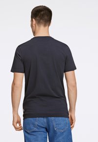 Navyblauw katoenen T-shirt met korte mouwen en een ronde hals, voorzien van een rechte zoom en subtiele stiklijnen aan de randen.