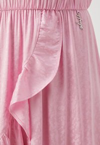 Pink dress featuring a textured fabric with a subtle pattern, ruffled side detail, elastic waistband, and silver hardware accent.