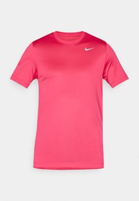 Różowa koszulka z krótkim rękawem, wykonana z gładkiego, lekkiego materiału. Posiada okrągły dekolt i małe białe logo Nike na klatce piersiowej.