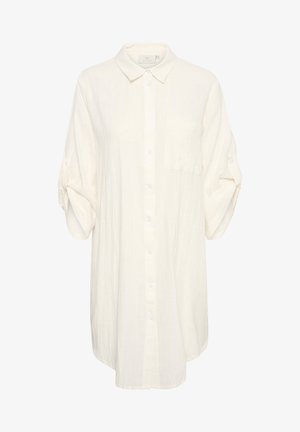Cremefarbenes langes Hemd aus leichtem Stoff. Mit durchgehender Knopfleiste, Kragen und einer Brusttasche. Mit hochrollbaren Ärmeln.