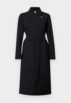 Melnas ceļgalu garuma tranča mētelis ar garām piedurknēm, jostu pie vidukļa, klasisku apkakli un slēptu priekšpuses aizdari uz balta fona.