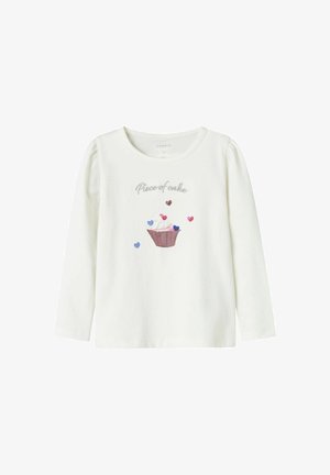 Weißes Langarmshirt mit dem Text "Stück Kuchen" über einem Cupcake und verstreuten pinken, blauen und braunen Herzen auf der Vorderseite.