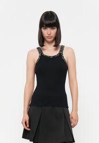 Top a maniche corte nero con costine, strisce decorate, design aderente e scollo a barca. Il tessuto appare liscio con una silhouette strutturata.