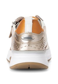 Schoen met metalen gouden en oranje leren accenten, witte mesh, geperforeerde details, dikke witte zool en een rits aan de zijkant.