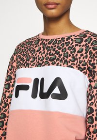 Felpa colorata con stampa leopardata nera e verde sulle maniche, una parte centrale bianca con un importante logo FILA nero e un fondo rosa.