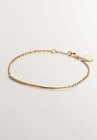 Pulsera de cadena de oro que presenta un elegante centro de barra curvada con cierre de langosta y un charm redondo adicional en una delicada cadena.