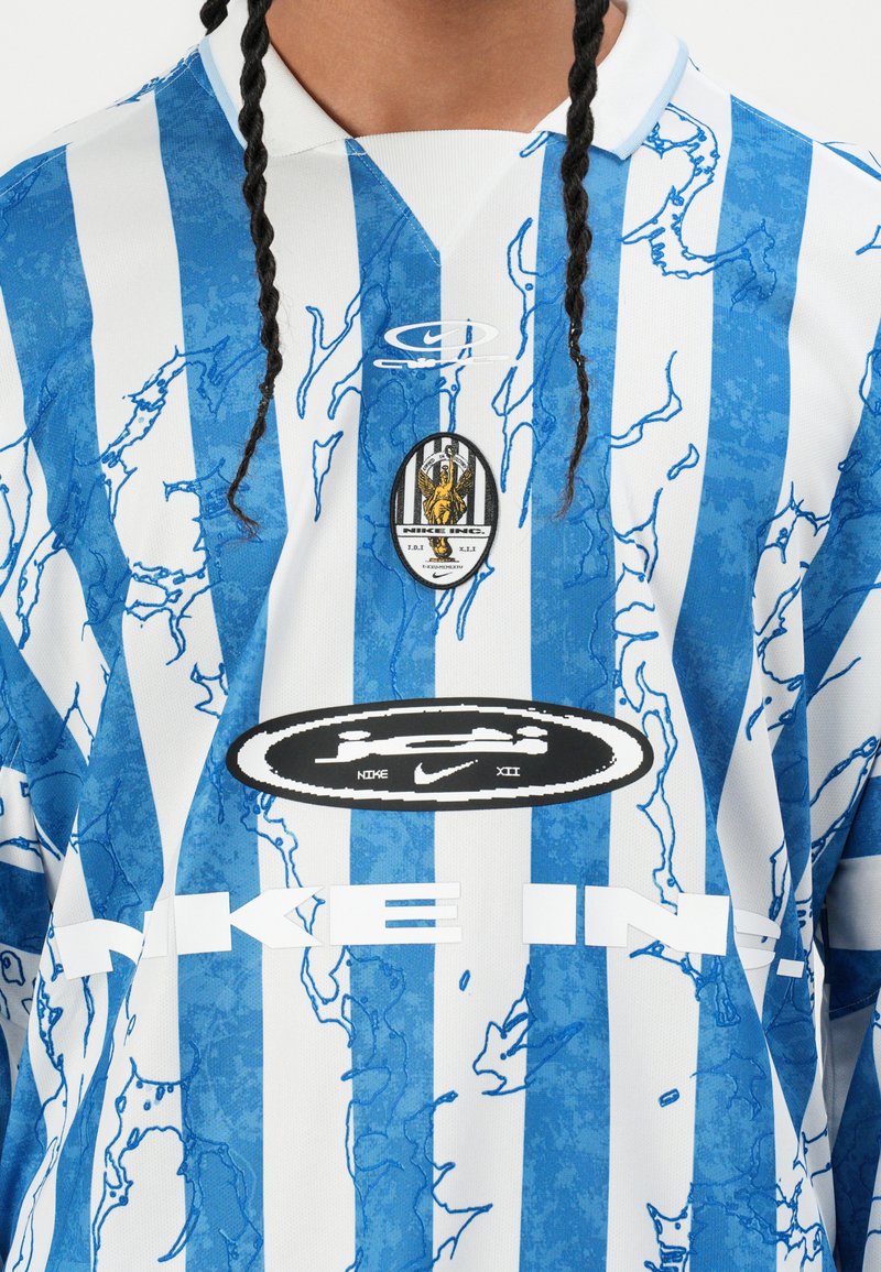 Jersey de manga larga a rayas azul y blanca con un diseño gráfico, que presenta un cuello redondo, logotipo bordado y tejido texturizado.