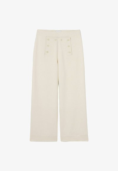 Pantalon large couleur crème avec une texture lisse, présentant des accents de boutons à l'avant et une taille plate sans passants de ceinture.