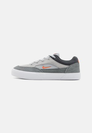 Gray suede sneaker with orange accents, featuring a low-top design, lace-up closure, and a white rubber sole. Textured upper panel details.