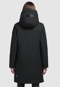 Abrigo acolchado negro con una gran capucha, textura suave y detalle del logo en la parte posterior. Mangas largas y diseño hasta la rodilla.