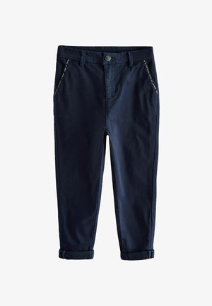 Tmavomodré nohavice s rovnými nohavicami s manžetami, pútkami na opasok, predným zapínaním na gombík a zips a šikmými vreckami s viditeľným prešívaním.