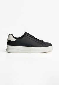 Schwarze Leder-Sneaker mit einer weißen Gummisohle, die eine glatte Oberfläche, eine runde Zehenpartie und einen kontrastierenden grauen Fersenakzent aufweisen. Mit Schnürdesign.