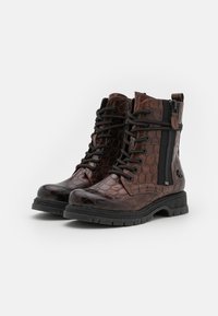 Bruine leren enkelboots met een textuur, geperforeerd patroon, zwarte veters, zijrits en een robuuste zool voor grip.