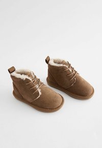 Braune Wildleder-Stiefeletten mit einem weichen, Kunstfellfutter, Schnürdesign und einer strapazierfähigen Gummisohle mit einer strukturierten Oberfläche.
