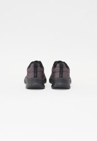 Black and purple athletic shoes with mesh upper, round toe, pull tab, and textured rubber sole. Rear view highlights padding and stitching details.