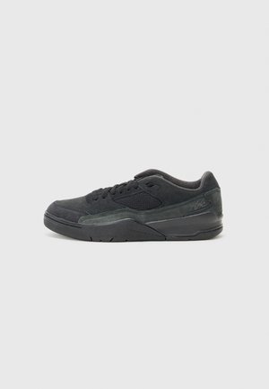 Black low-top sneaker with suede and mesh upper, lace-up closure, padded collar, and thick rubber sole, shown from the side on a light background.