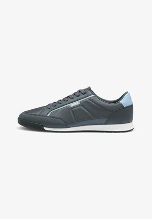 Dark gray athletic shoe with mesh and synthetic materials, accented with light blue. Features a white sole and subtle geometric texture.