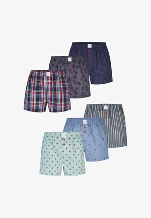 Zes paar herenshortbroeken in verschillende patronen: marineblauwe polkadots, grijze palmbomen, rood geruit, lichtgroene palmbomen, blauw met kleine printjes en grijze strepen.