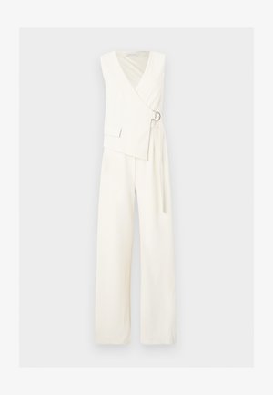 Begalviai baltas kombinezonas su plačiomis kojomis, priekyje įvyniojimo stiliaus, užsegamas sidabriniu žiediniu sagtimi, išsiuvinėtas mažas kišenės detalės viršutiniame kairiajame kampe.