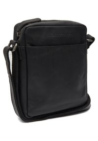 Borsa a tracolla nera in pelle con texture liscia, chiusura zip, tracolla regolabile e logo impresso sul davanti. Forma rettangolare.