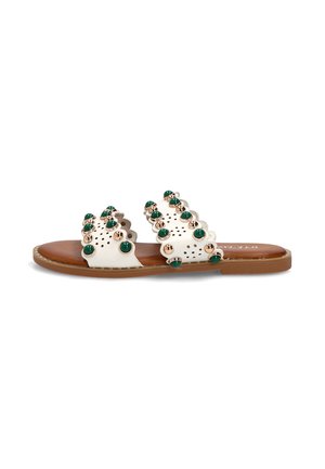 Sandalia blanca de cuero tipo slide con dos tiras con bordes ondulados decoradas con tachuelas redondas verdes y doradas y una suela plana marrón.