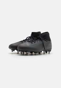 Crampons de football noirs avec un dessus texturé, un design à cheville haute et des lacets noirs. Pointes transparentes sur la semelle extérieure pour une traction sur les surfaces herbeuses.