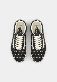 Black sneakers with white lace, featuring a fabric upper adorned with small floral patterns, classic design with rubber sole.