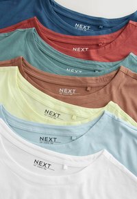Stapel von sieben gefalteten T-Shirts mit Rundhalsausschnitt in Blau, Rot, Grün, Braun, Gelb, Hellblau und Weiß, jeweils mit der Aufschrift "NEXT Cap Sleeve Tee".