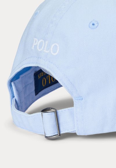 Șapcă de baseball ajustabilă, de culoare albastru deschis, cu cataramă metalică, text brodat „POLO” pe spate și o etichetă din material textil în interiorul curelei.