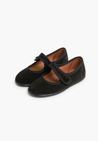 Sorte ruskind ballet flats med rund tå, der har en bred strop over vristen og en cirkulær detalje ved slutningen af stroppen. Flad gummisål.