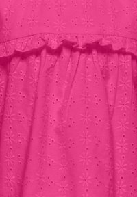 Robe rose avec un tissu texturé orné de broderies florales, des détails froncés à la taille et une jupe froncée.