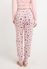 Pantalones de pijama rosas hechos de una tela suave presentan un patrón divertido con pingüinos, bebidas y accesorios de verano. Cintura elástica, corte entallado.