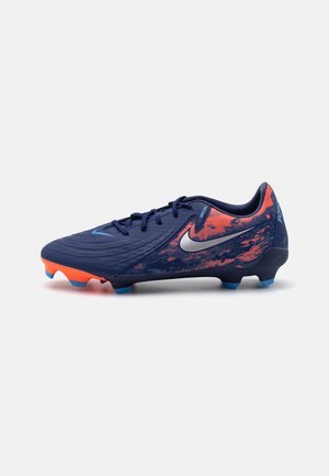 Crampon de football Nike Mercurial en bleu marine avec des crampons de semelle orange et bleus, présentant un swoosh argenté et un motif éclaboussé orange sur le talon.