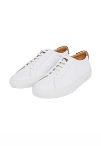 Baskets en cuir blanc avec une texture lisse, dotées d'un bout rond, d'un système de laçage et d'un accent marron au niveau du talon. Semelle en caoutchouc.