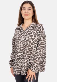 Leopardenmuster-Hemd mit Druckknöpfen aus leichtem Stoff, mit lockerer Passform, Kragen und langen Ärmeln. Die Farbkombination umfasst Beige, Schwarz und Grau.