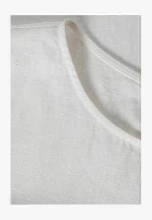 Leinenoberteil mit rundem Ausschnitt, ausgestattet mit einer weichen weißen Textur und subtilen Webmuster. Saubere Kanten und minimalistisches Design.