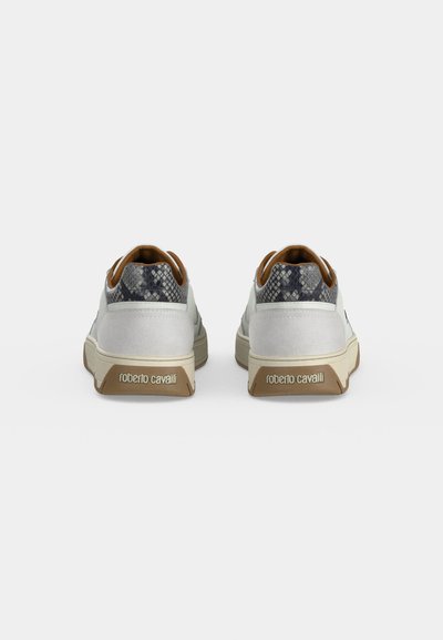 Ζευγάρι λευκά sneakers με λεπτομέρειες φιδίσιου μοτίβου στον κολάρο της φτέρνας και λογότυπο "roberto cavalli" στις καφέ λαστιχένιες σόλες.
