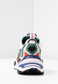 Färgglad sneaker med en blandning av läder och mesh-material, med rundad tå, texturerade detaljer och vadderad krage.