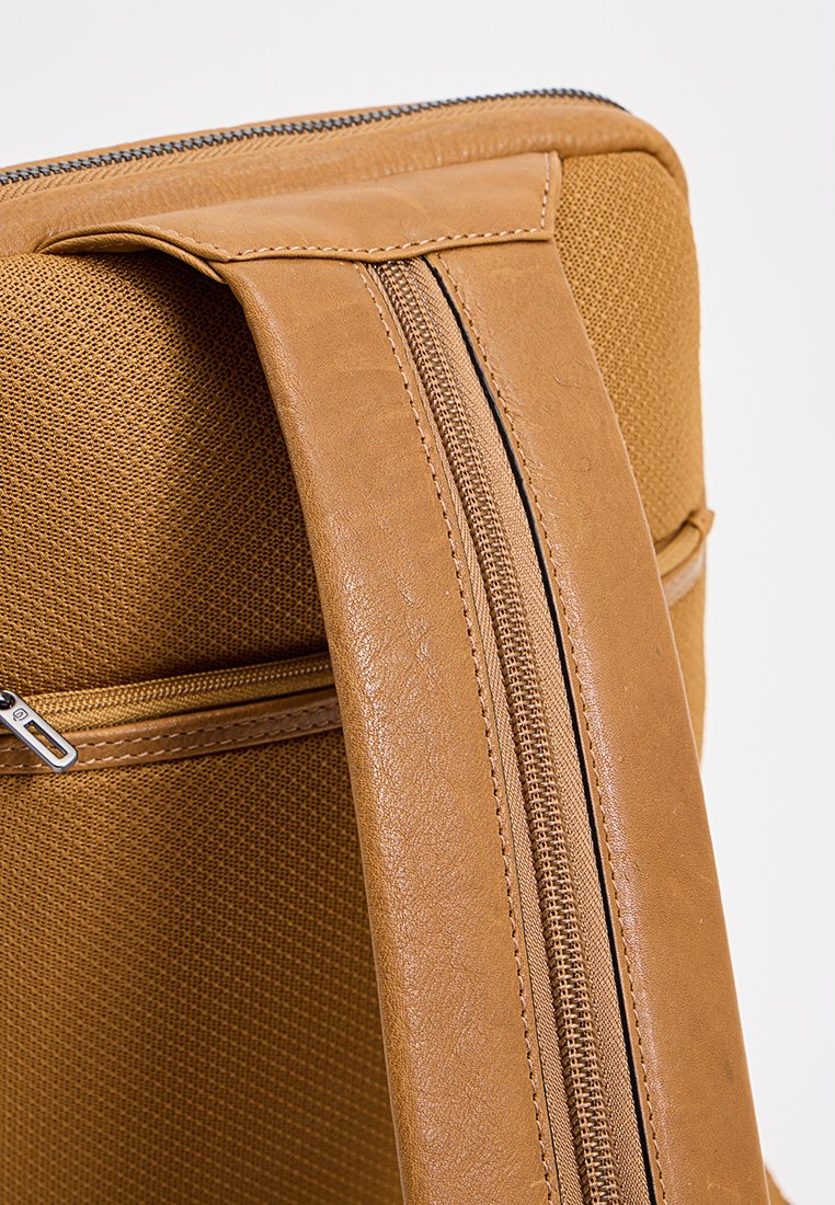 Borsa in pelle marrone e tessuto beige testurizzato, dotata di una cerniera liscia e di un manico strutturato nella parte superiore per un facile trasporto.