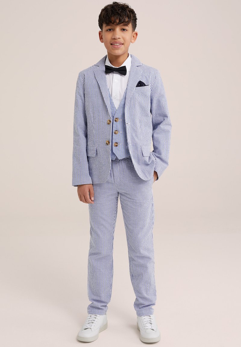 Costume rayé bleu et blanc avec une veste croisée et un pantalon assorti, complété par une chemise blanche et un nœud papillon noir.