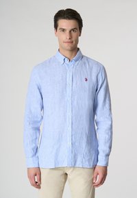Camicia button-up a righe blu e bianche realizzata in un tessuto leggero, con un colletto classico, maniche lunghe e un piccolo logo rosso sul petto.