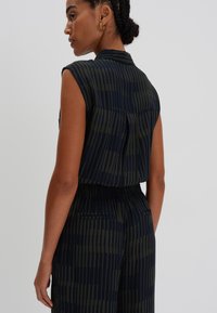Sleeveless blouse in dark blue and olive green with vertical stripes, featuring a collar and a back pleat for added detail.