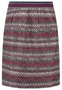 Jupe au-dessus du genou avec un motif en zigzag bordeaux, noir et crème. Elle possède une ceinture foncée unie et des plis.