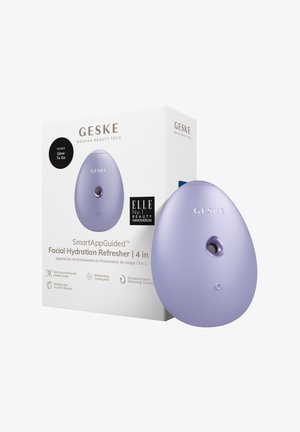 Lila äggformad ansiktsfuktighetsapparat med en knapp på framsidan och en liten sensor. Förpackningen inkluderar varumärkning och produktinformation i svart och vitt.