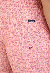 Pantaloni corti a fantasia in tessuto pesca con motivi di palme rosa, cintura elastica e una tasca a toppa con chiusura a pressione in metallo.