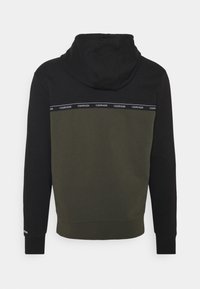 Felpa con cappuccio caratterizzata da un design a blocchi di colore nero e verde oliva, con una banda con logo Calvin Klein sulla parte superiore della schiena. Tessuto morbido.
