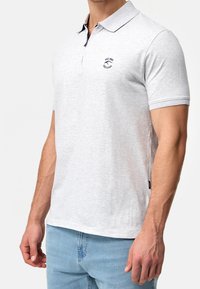 Polo grigio chiaro realizzato in misto cotone, con colletto classico, maniche corte e un piccolo logo navy sul petto.