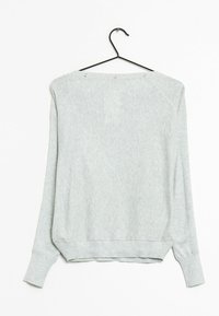 Jasnoszara bluza z długim rękawem w lekko oversizedowym fasonie, z prążkowanymi mankietami i zaokrąglonym hemem. Posiada zatrzaski przy dekolcie.