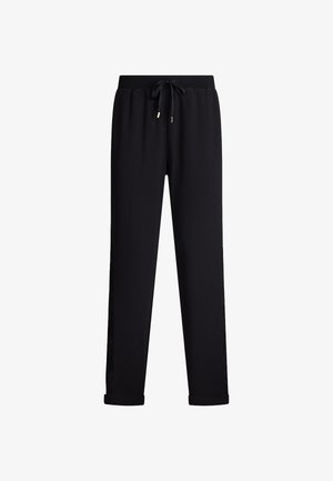 Pantaloni sportivi neri con vita regolabile tramite coulisse, gambe affusolate e orli arrotolati, dotati di pannelli laterali texture per un tocco di dettaglio in più.